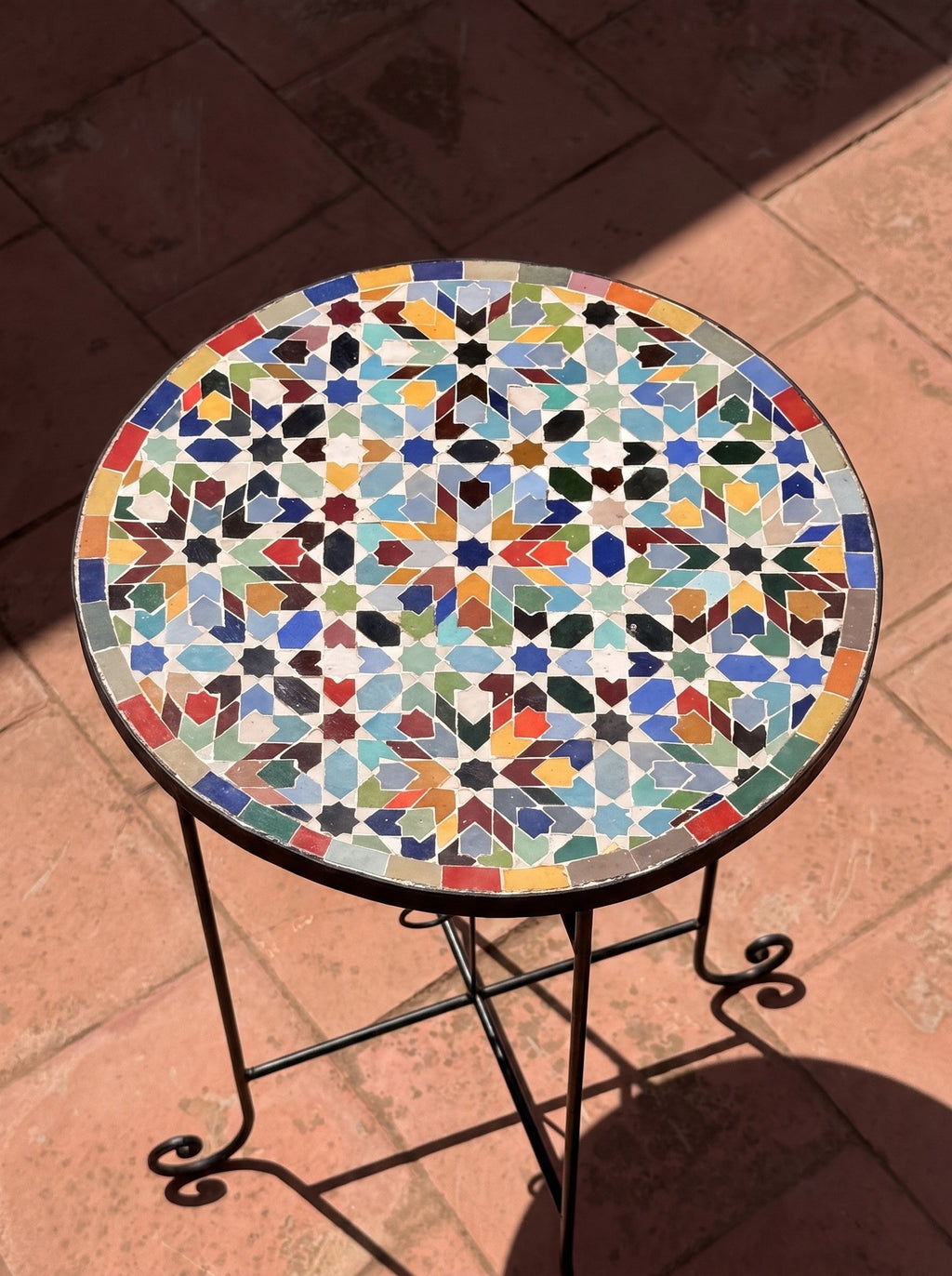 Bahja zellige side table on a terracotta terrace in sunlight