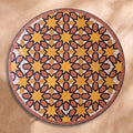 Chems zellige tabletop seen from above, Meknès outlined stars in ochre and terracotta with black outlines