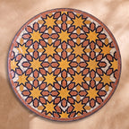 Chems zellige tabletop seen from above, Meknès outlined stars in ochre and terracotta with black outlines