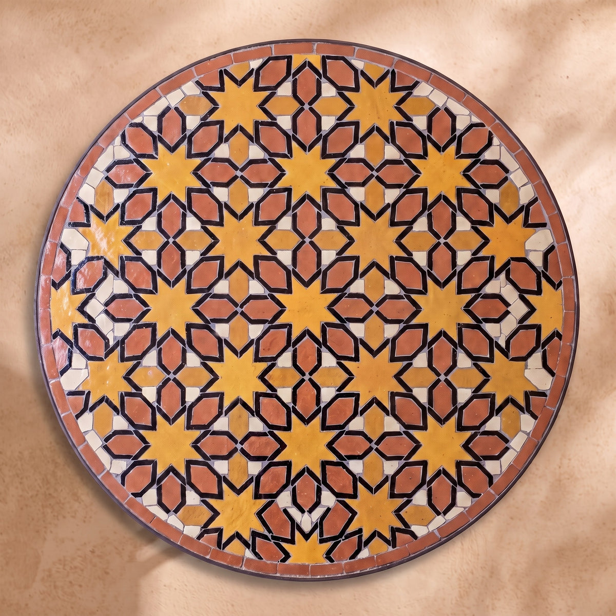 Chems zellige tabletop seen from above, Meknès outlined stars in ochre and terracotta with black outlines