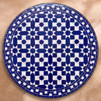 Fassia zellige tabletop seen from above, cobalt eight-point star lattice with a stepped border on white, inspired by Fez embroidery