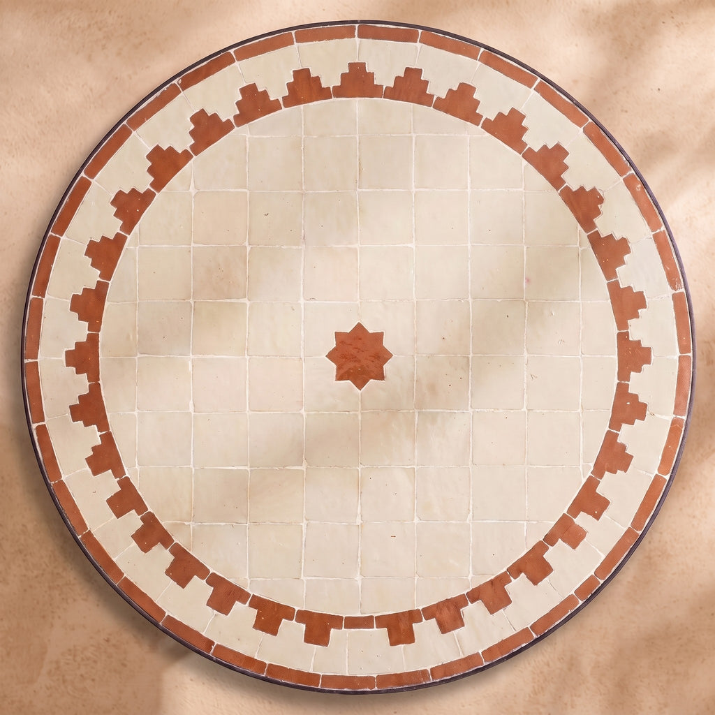 Hamra zellige tabletop seen from above, Fez stepped border and centre star in terracotta on cream