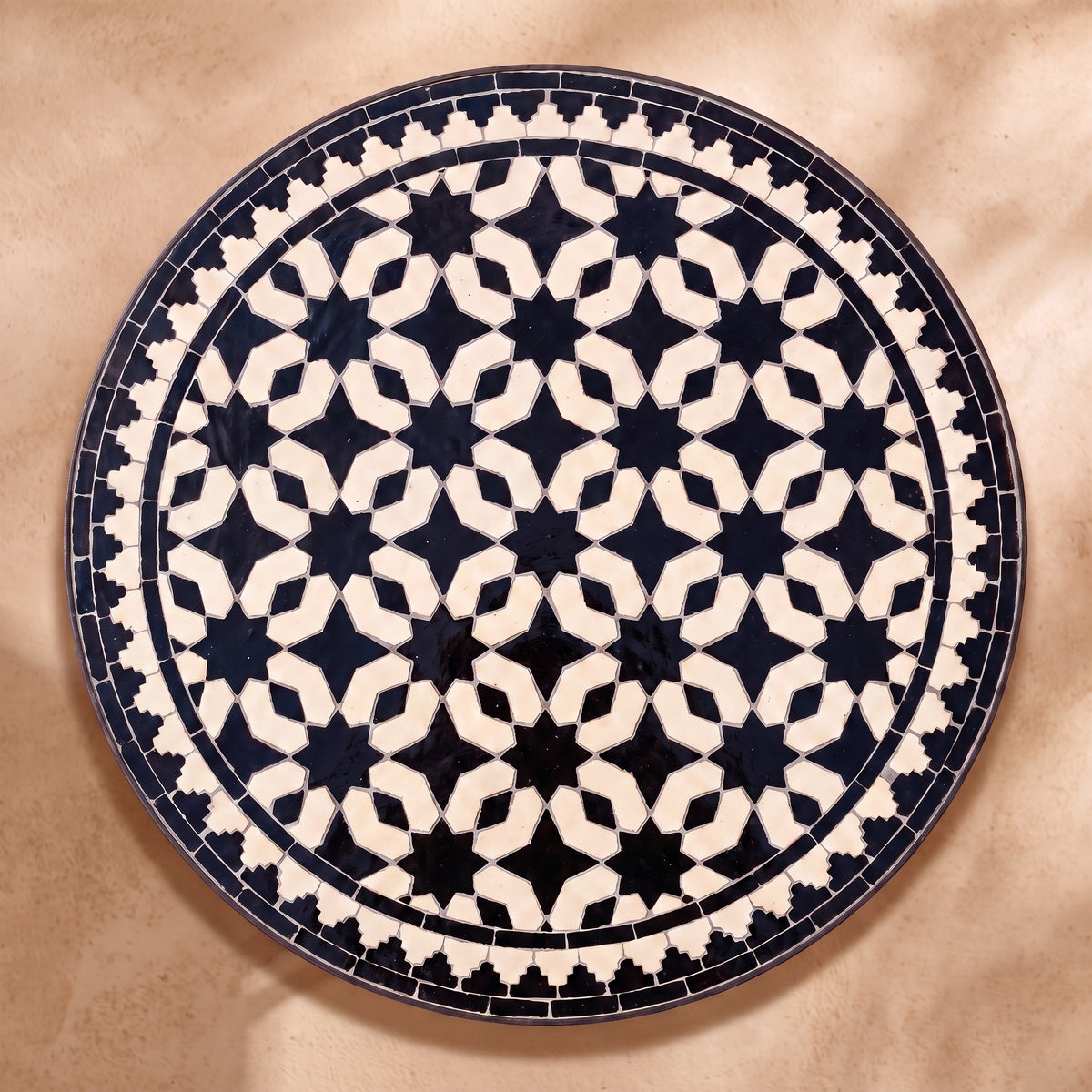 Hbar zellige tabletop seen from above, Fez star lattice in black on cream