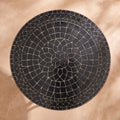 Kahla zellige mosaic side table seen from above, concentric rings of glossy black hand-cut tiles with pale joints, colour rendering of the design