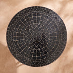 Kahla zellige mosaic side table seen from above, concentric rings of glossy black hand-cut tiles with pale joints, colour rendering of the design