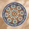 Kawkab handmade Beldi zellige tabletop seen from above, honey amber star ringed by green hexagons and stars inside a navy ring and white diamond border