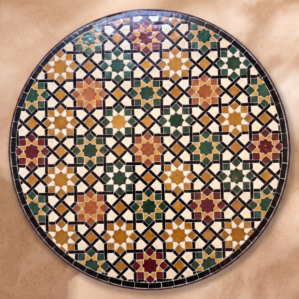 Meknassia zellige tabletop seen from above, warm red, ochre and green stars outlined in black strips on cream, inspired by Meknès embroidery