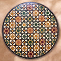 Meknassia zellige tabletop seen from above, warm red, ochre and green stars outlined in black strips on cream, inspired by Meknès embroidery