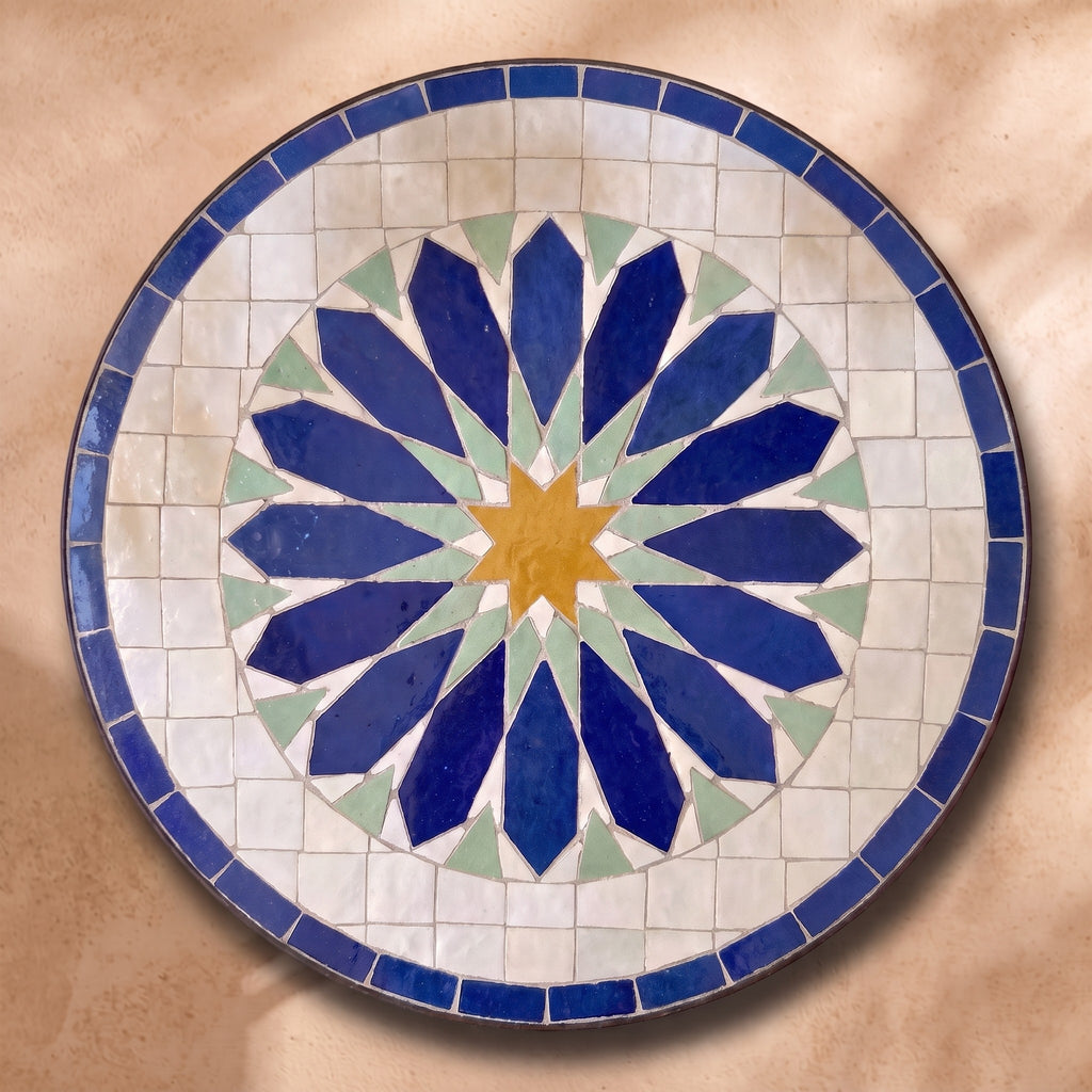 Rbatia zellige tabletop seen from above, a large flower of lozenge petals in cobalt, ochre and celadon on white, inspired by Rabat embroidery