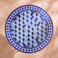 Zarqa zellige mosaic side table seen from above, tumbling cubes in Majorelle blue, cobalt and sky blue with a blue and white diamond border, colour rendering of the design